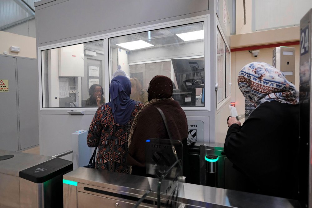 Palestinian women line up to show an Israeli soldier their identity card and permit, if needed, to gain access to Jerusalem