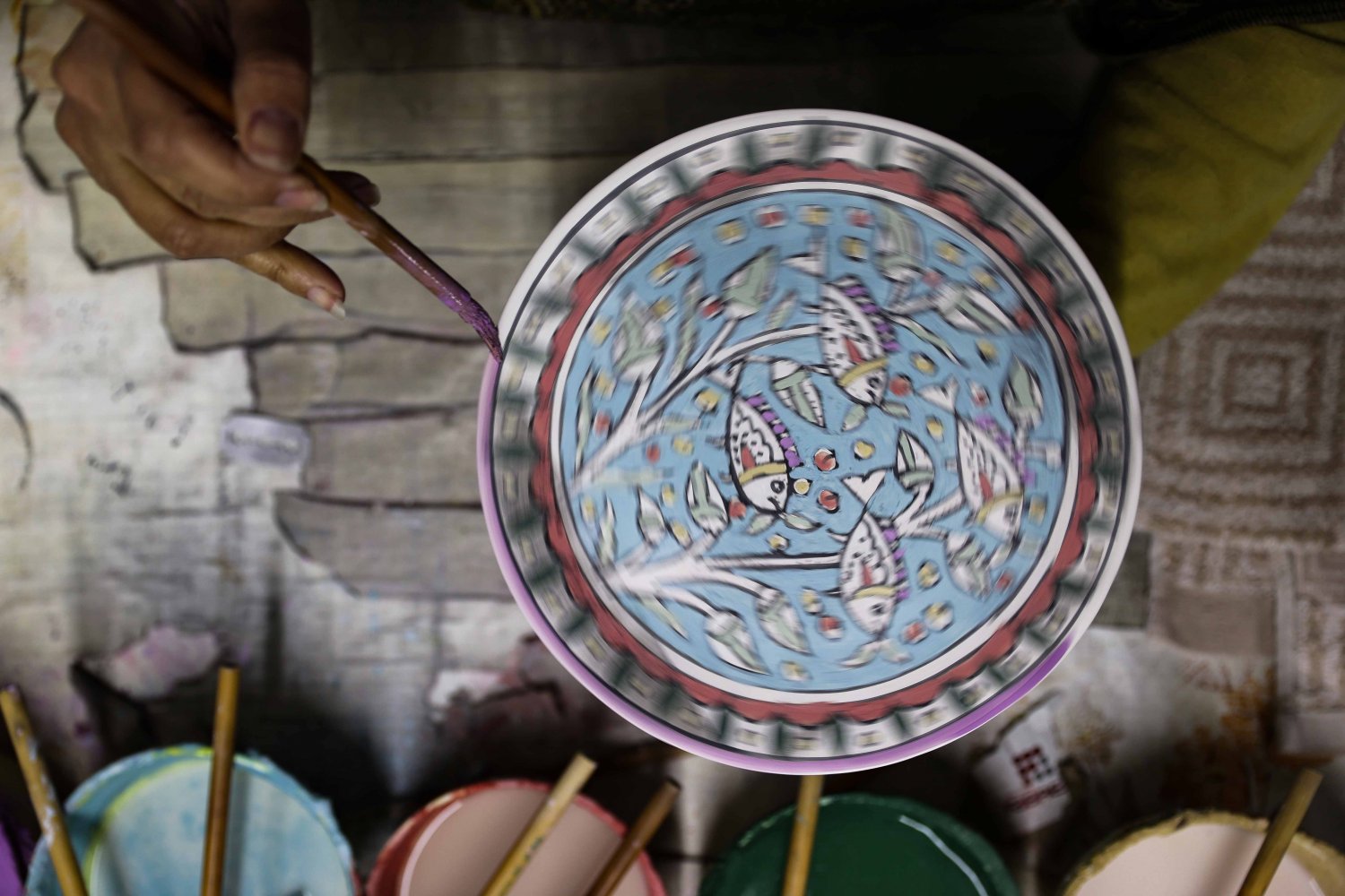 A ceramic artist handpaints the rim of an Armenian pottery plate at the Balian workshop in Jerusalem
