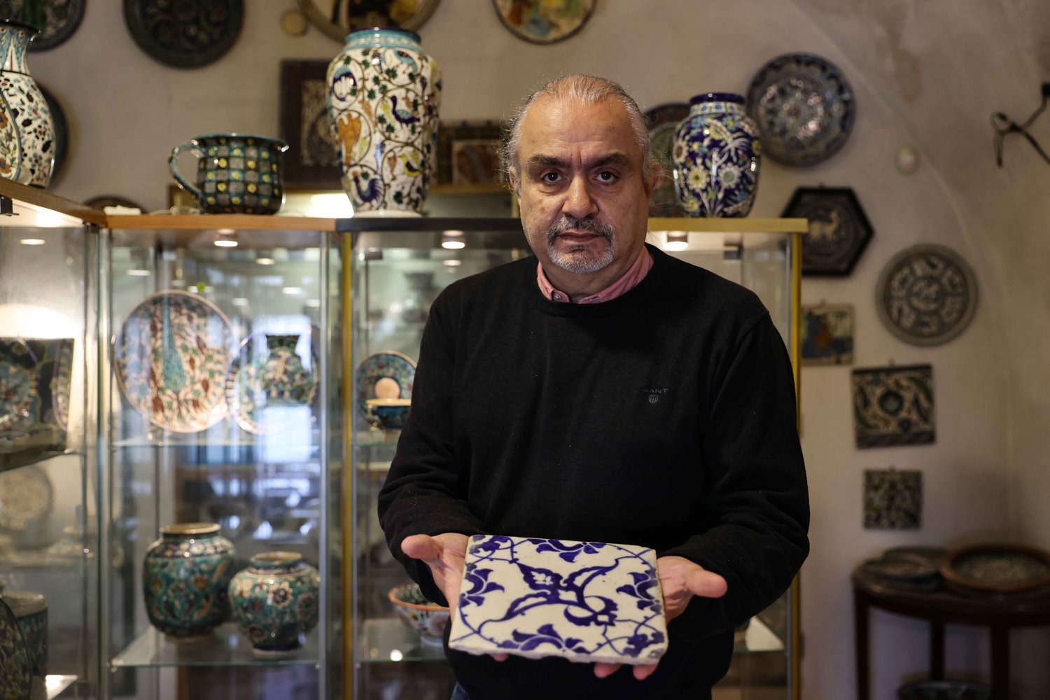 Neshan Balian Jr. holds a historic tile displayed in the museum of the Balian design studio in East Jerusalem